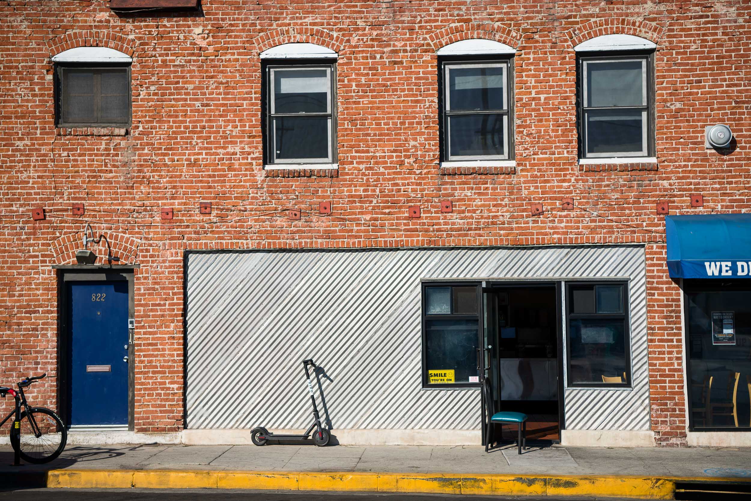 A Bird scooter parked outside a restaurant in Venice Beach.