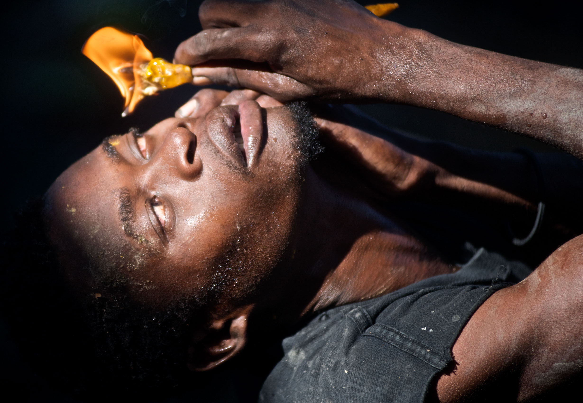 A man holds a flame to his eye during the Plaine du Nord voodoo ceremony in northern Haiti.
