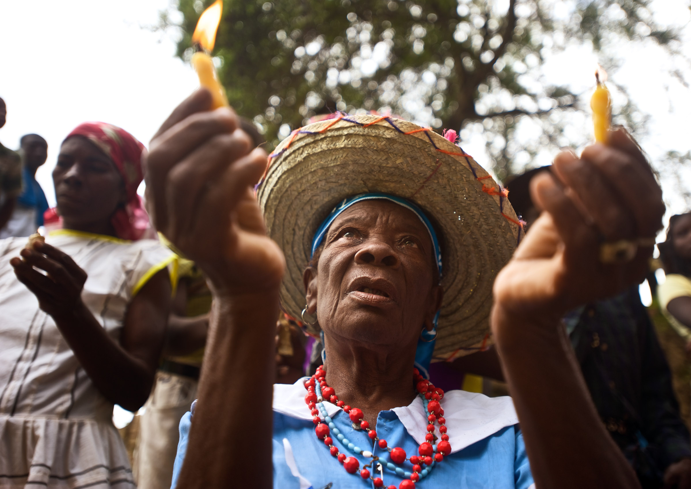 A woman holds candles during the Saut D