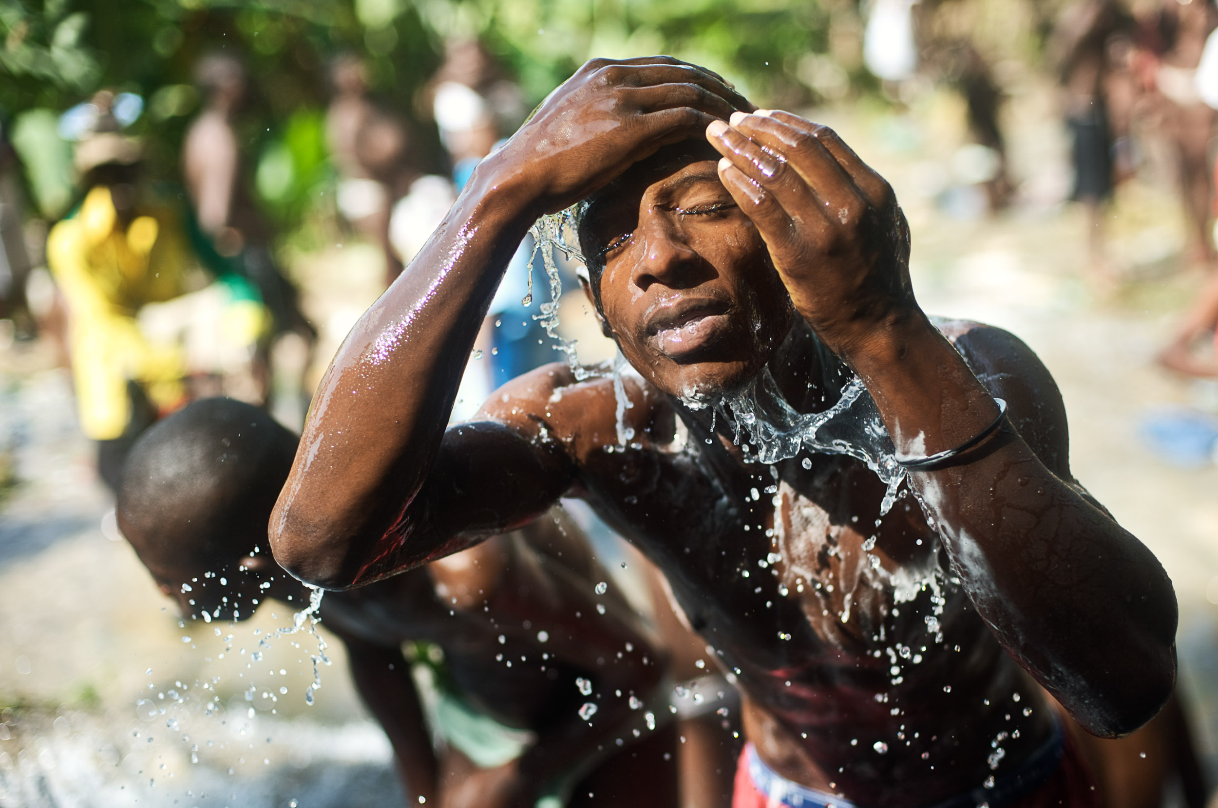 A man splashes water on his face during the Saut D