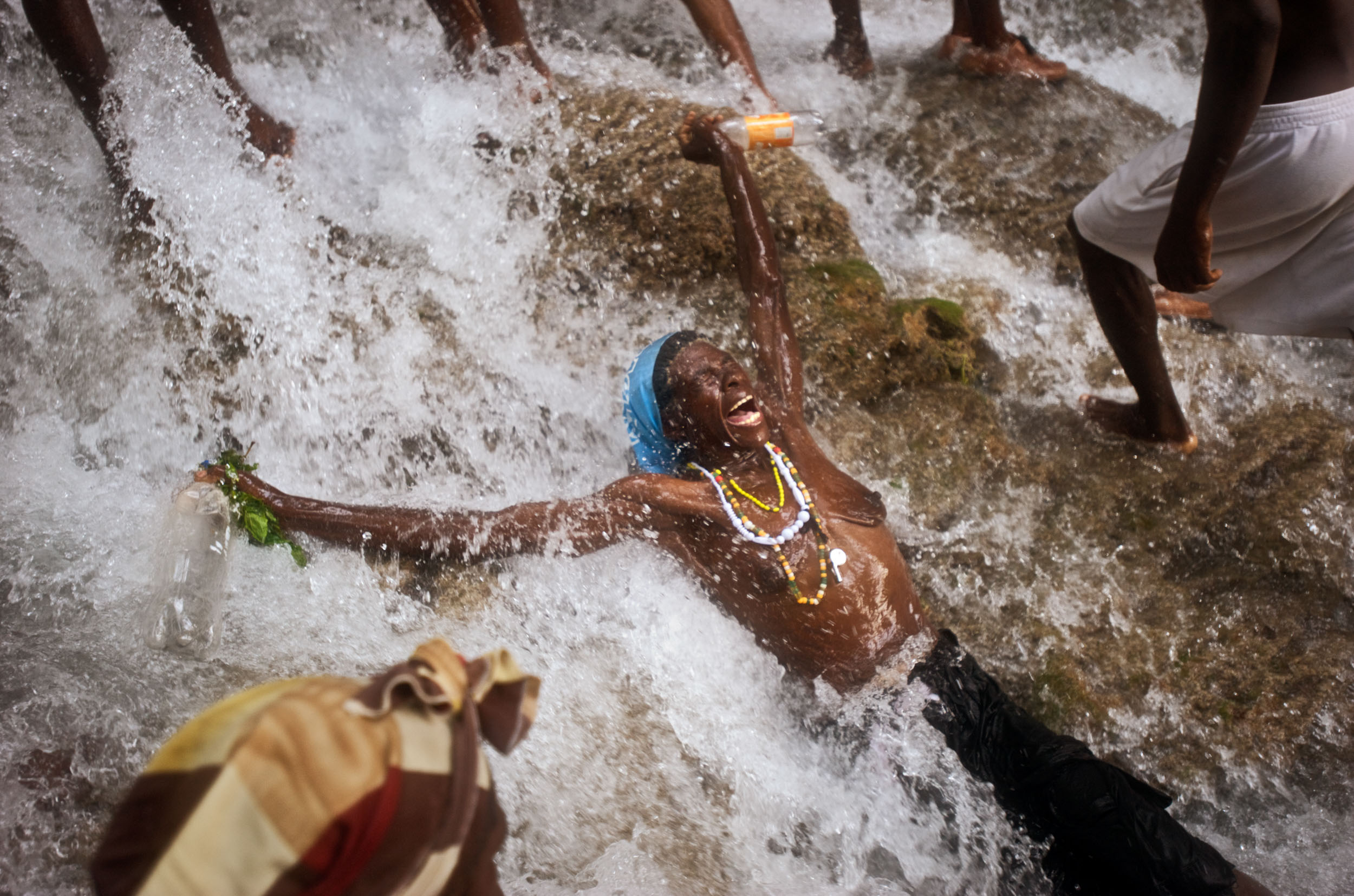 A woman worships in a waterfall during the Saut D