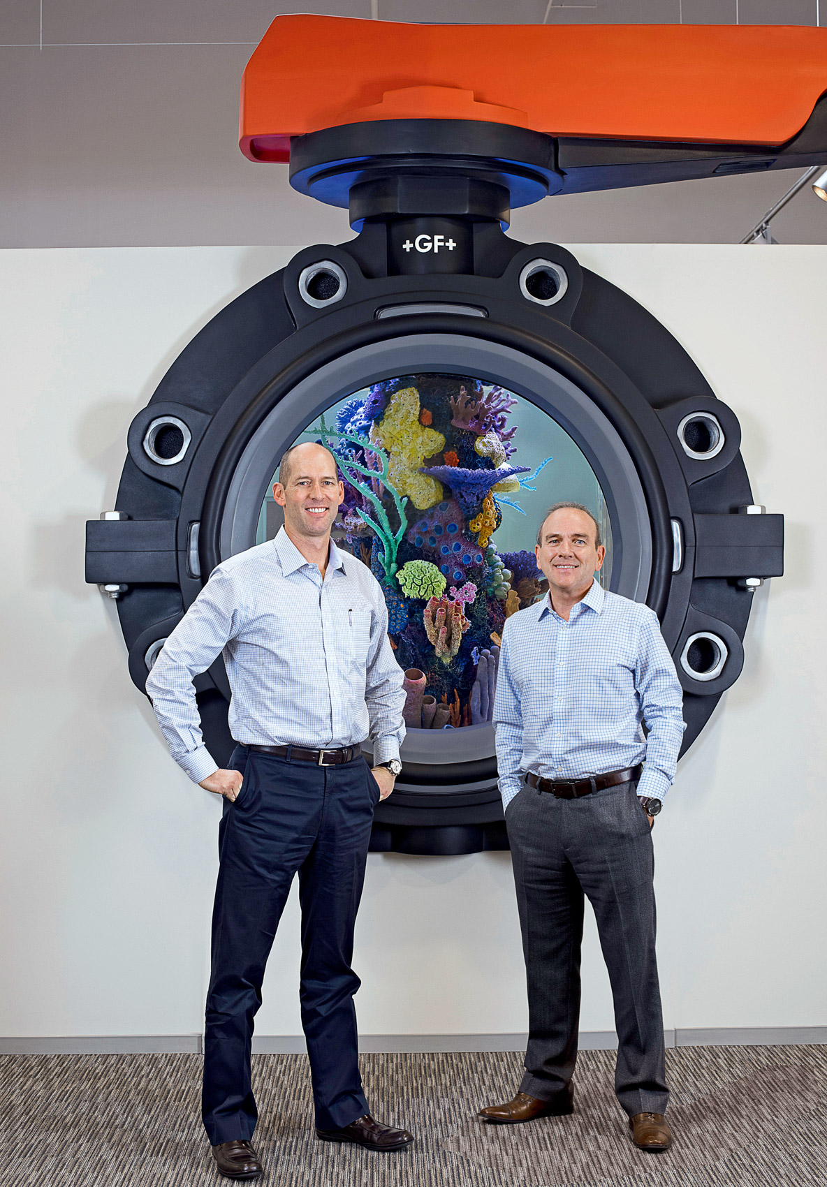 Portrait of two male executives in front of a fish tank at Georg Fischer in Irvine, Calif.
