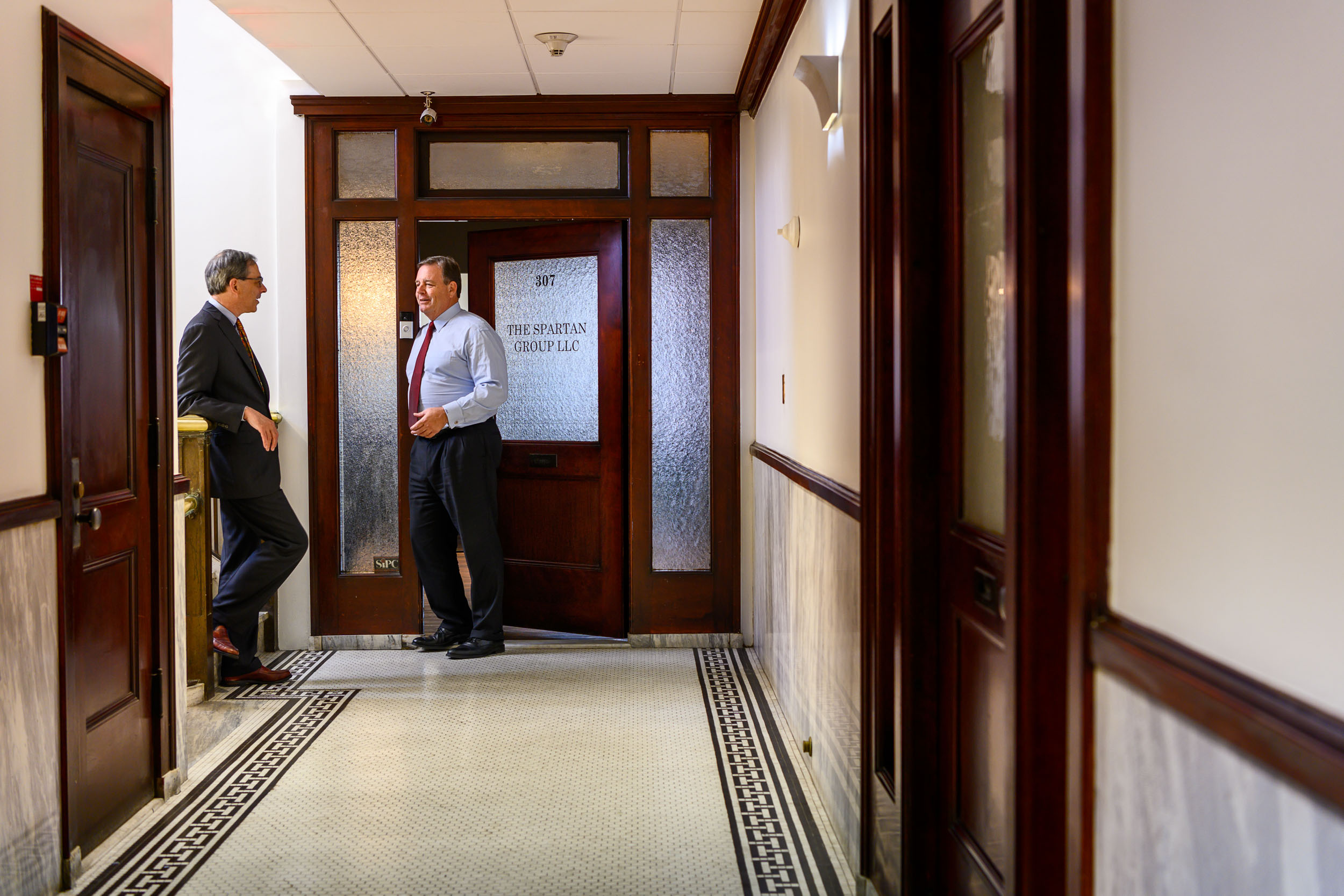 Two investment banking executives meet in the hallway outside their office in Pasadena, Calif.