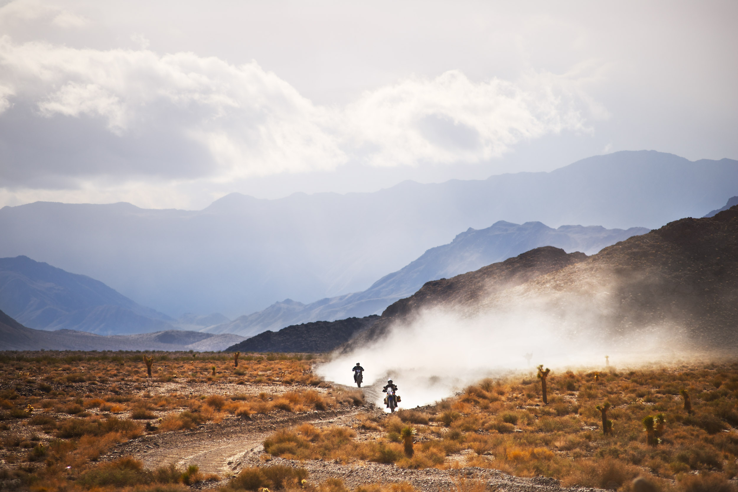 Dirt bike riders leave a cloud of dust in Death Valley National Park.