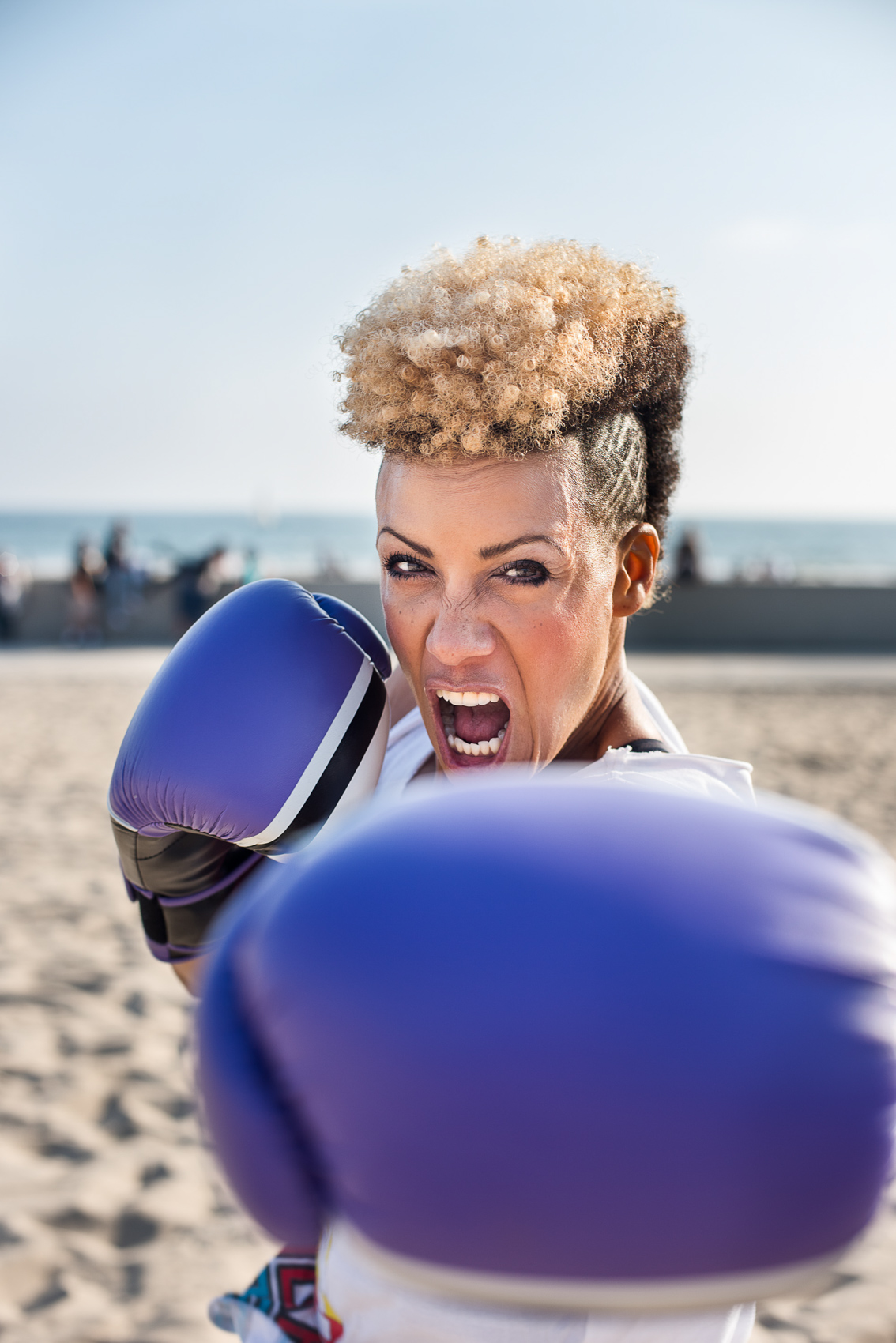A female boxer punches at the camera in Venice Beach, Calif.