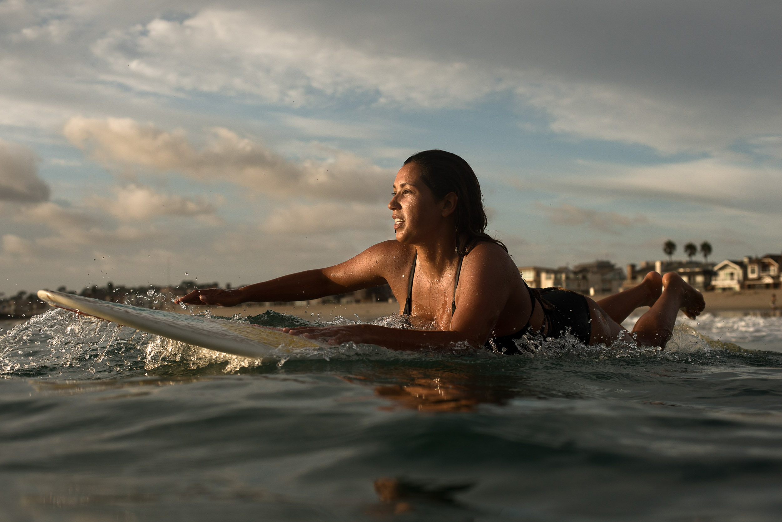 A professional female surfer paddles out in Newport Beach, Calif.