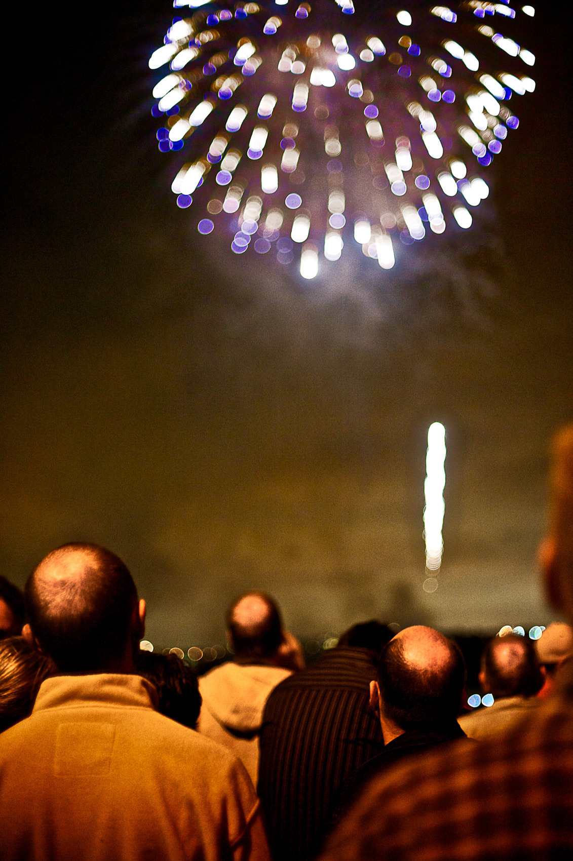 A group of bald heads watch fireworks in Marina del Rey, Calif. on the 4th of July.