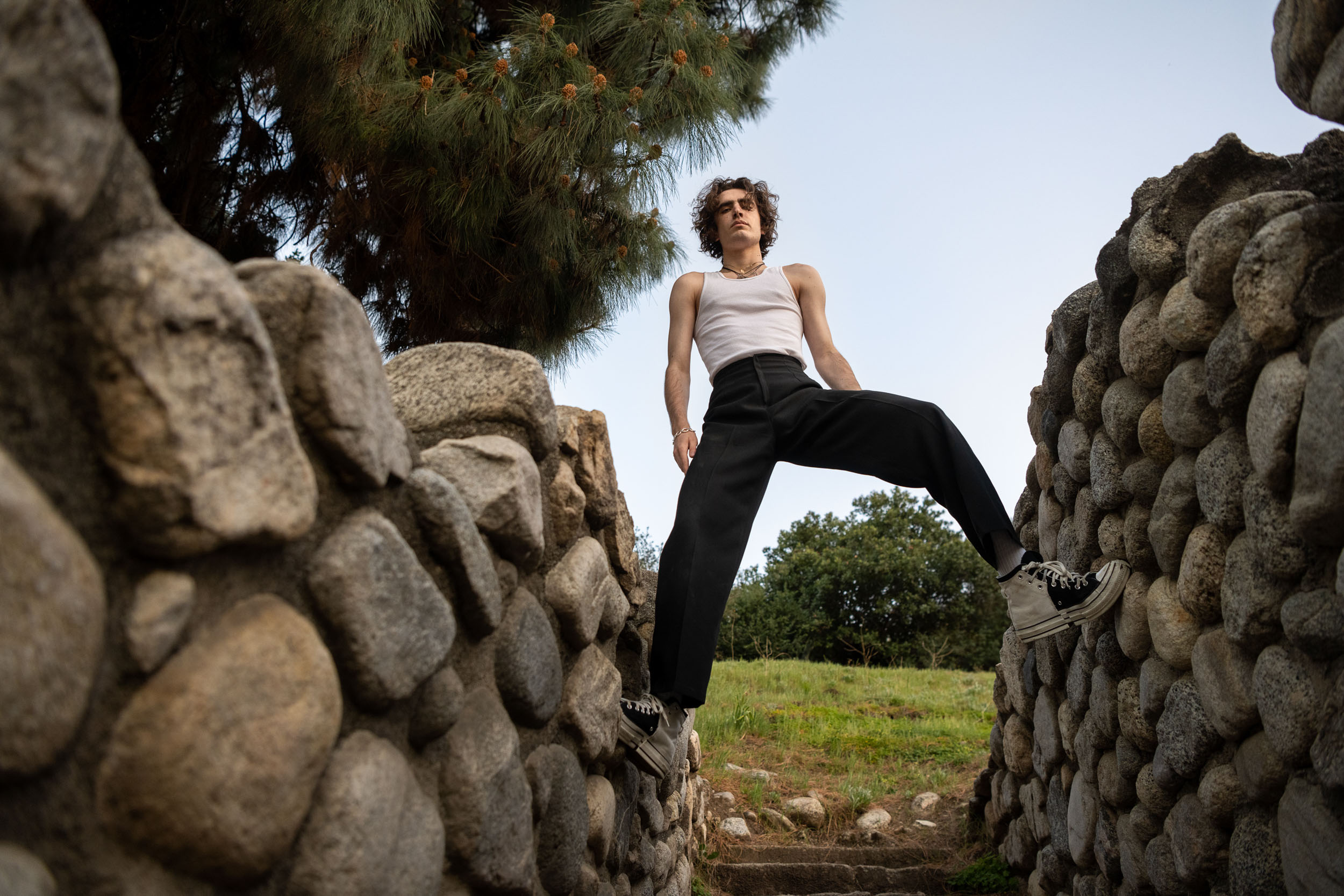 A male model stands over a stone staircase in Los Angeles.