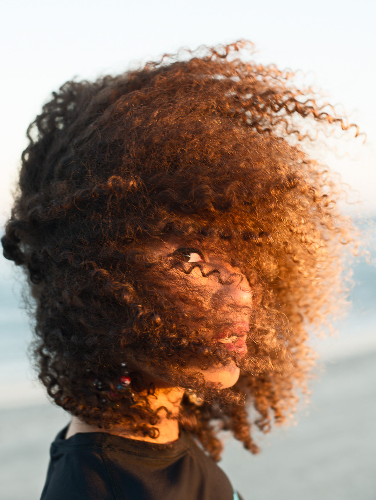 Portrait of a female model with her eye framed by her hair in Malibu, Calif.