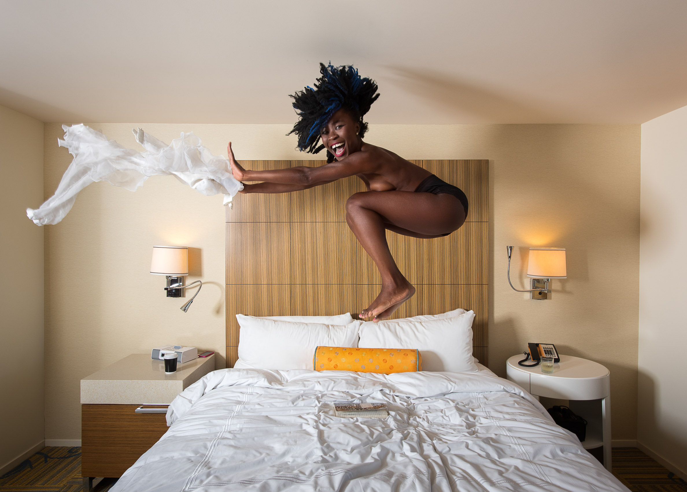 A woman jumps on the bed at the Ritz Carlton in downtown Los Angeles.