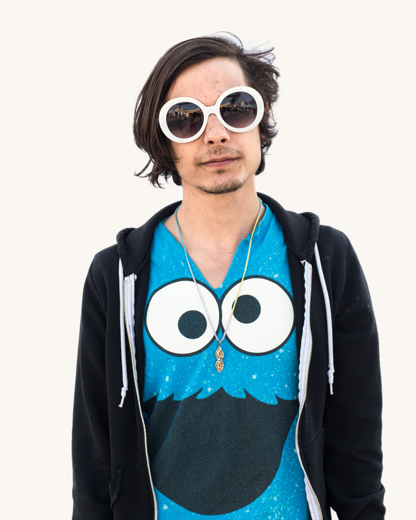 Man in Cookie Monster teeshirt Venice Beach street portrait series on white backdrop.