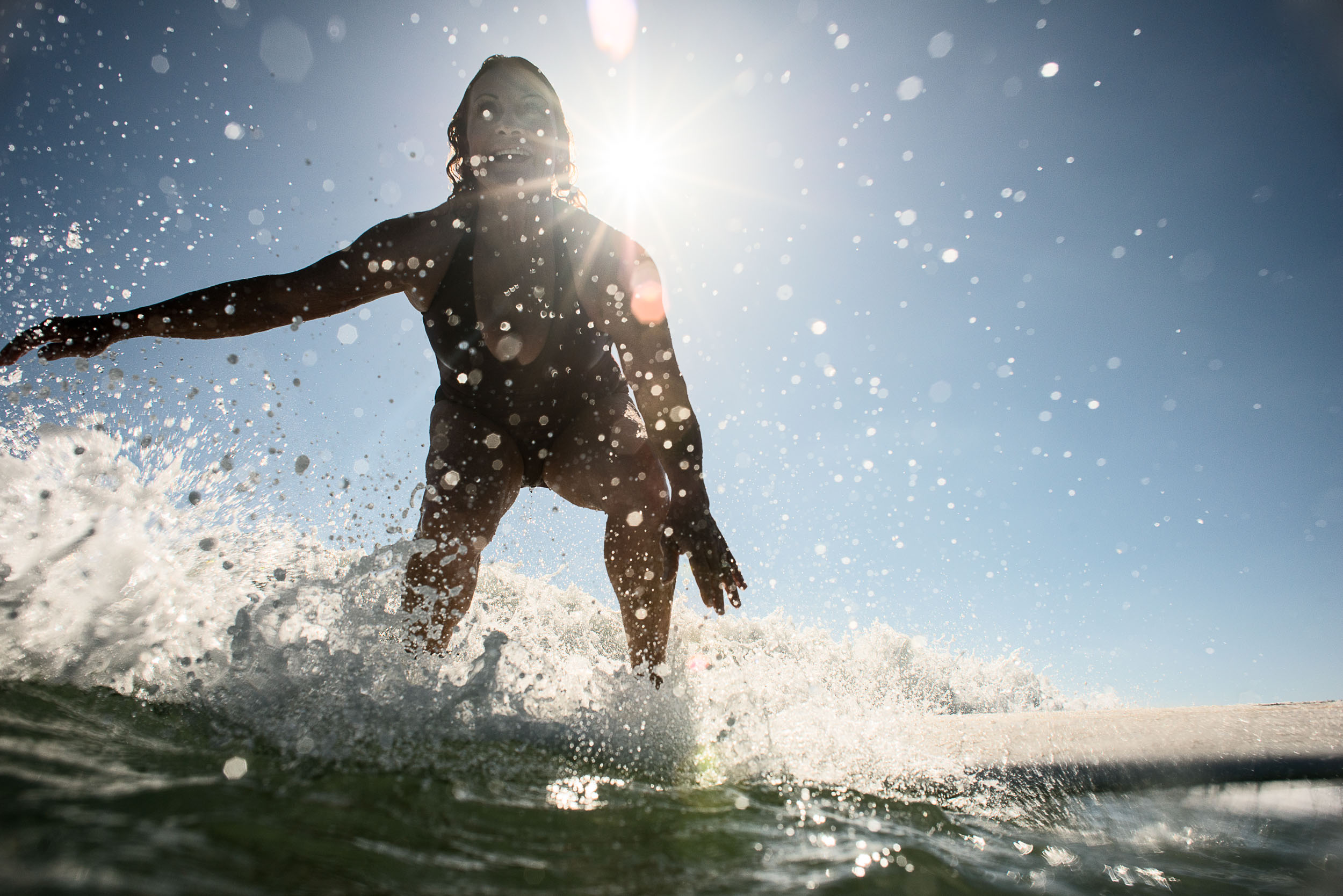 An older woman surfer catches a wave in Doheny State Beach, Calif.